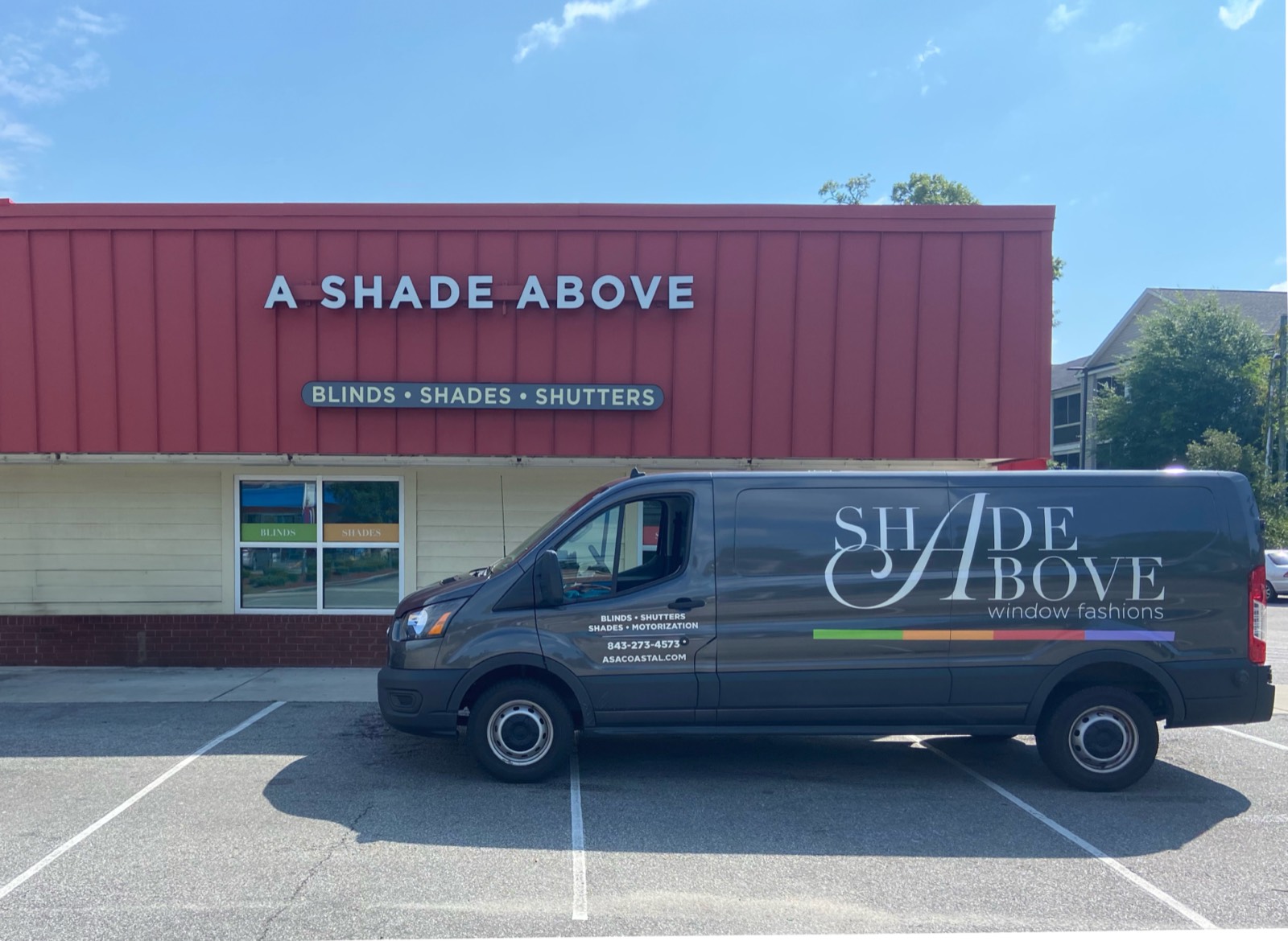 The Cherry Grove showroom — the little red-roofed A Shade Above shop on Sea Mountain Hwy with the wrapped van parked out front.